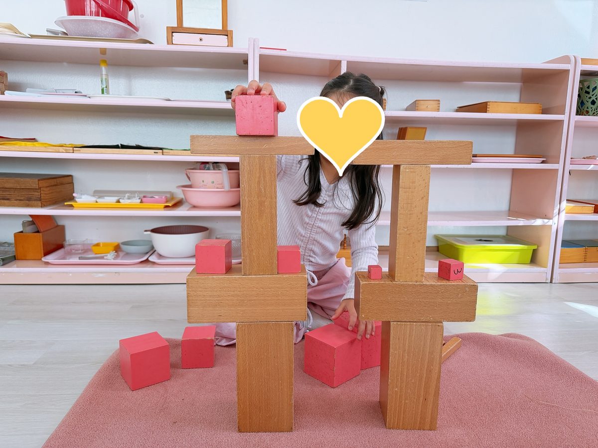 안산 은빛유치원 몬테소리 — 분홍 탑과 갈색 계단으로 기둥 둘을 세우고 다리를 놓은 아이