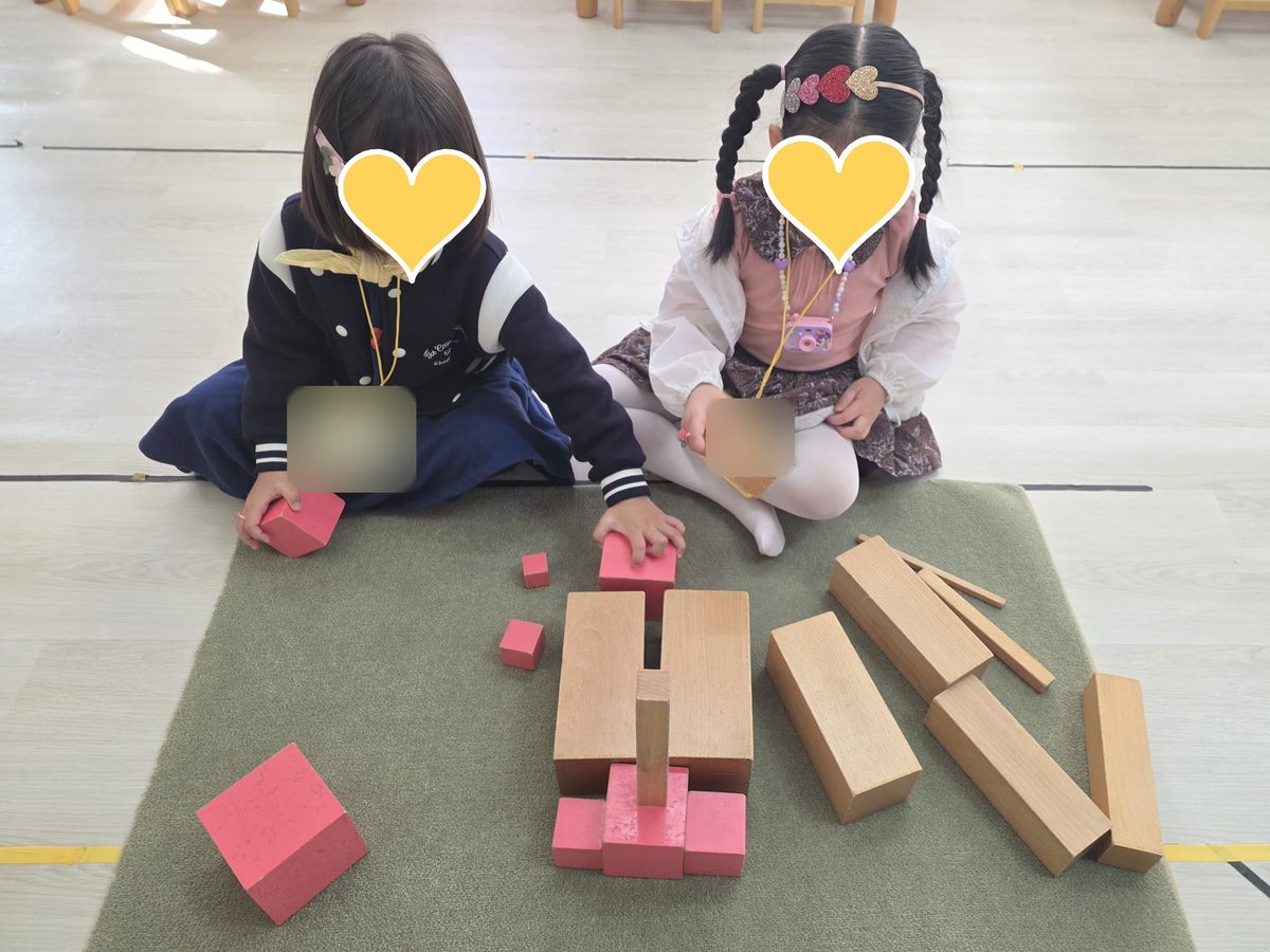 안산 은빛유치원 몬테소리 — 분홍 탑과 갈색 계단으로 함께 집을 짓는 두 아이